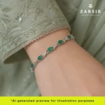 A woman wearing a Genuine Emerald Silver Tennis Bracelet paired with an elegant dress for a sophisticated evening look.