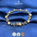 Extreme close-up of the handcrafted oxidised silver leaf detailing and bezel-set white opal cabochon on the 925 sterling silver bracelet