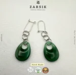 Pair of handmade 925 silver green teardrop dangle earrings on a luxury soft background.