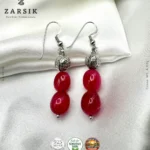Pair of Handmade 925 Silver Dangle Earrings with oval red stones on a luxury soft background.