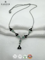 Close up of emerald and sapphire stones and floral marquise design on 925 silver rhodium plated Y necklace