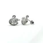 Pair of imported rhodium-plated 925 sterling silver swan stud earrings resting on a white surface, featuring mixed round and baguette-cut cubic zirconia and butterfly backs