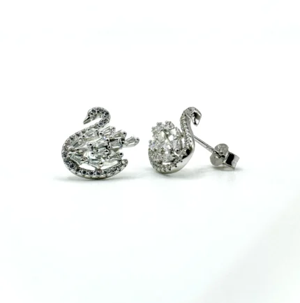 Pair of imported rhodium-plated 925 sterling silver swan stud earrings resting on a white surface, featuring mixed round and baguette-cut cubic zirconia and butterfly backs
